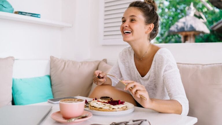 mulher sentando sorrindo durante refeição